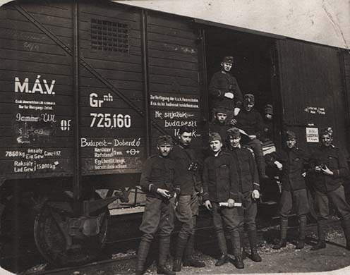 Katonák egy Budapest–Doberdó feliratú vasúti kocsi mellett