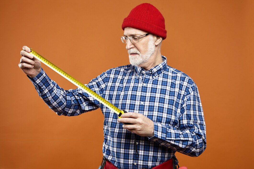 retired-caucasian-handyman-laborer-wearing-eyeglasses-red-knitted-hat-plaid-shirt-holding-measuring-tape-while-doing-renovation-taking-measurements-having-serious-concentrated-look_343059-2721.jpg