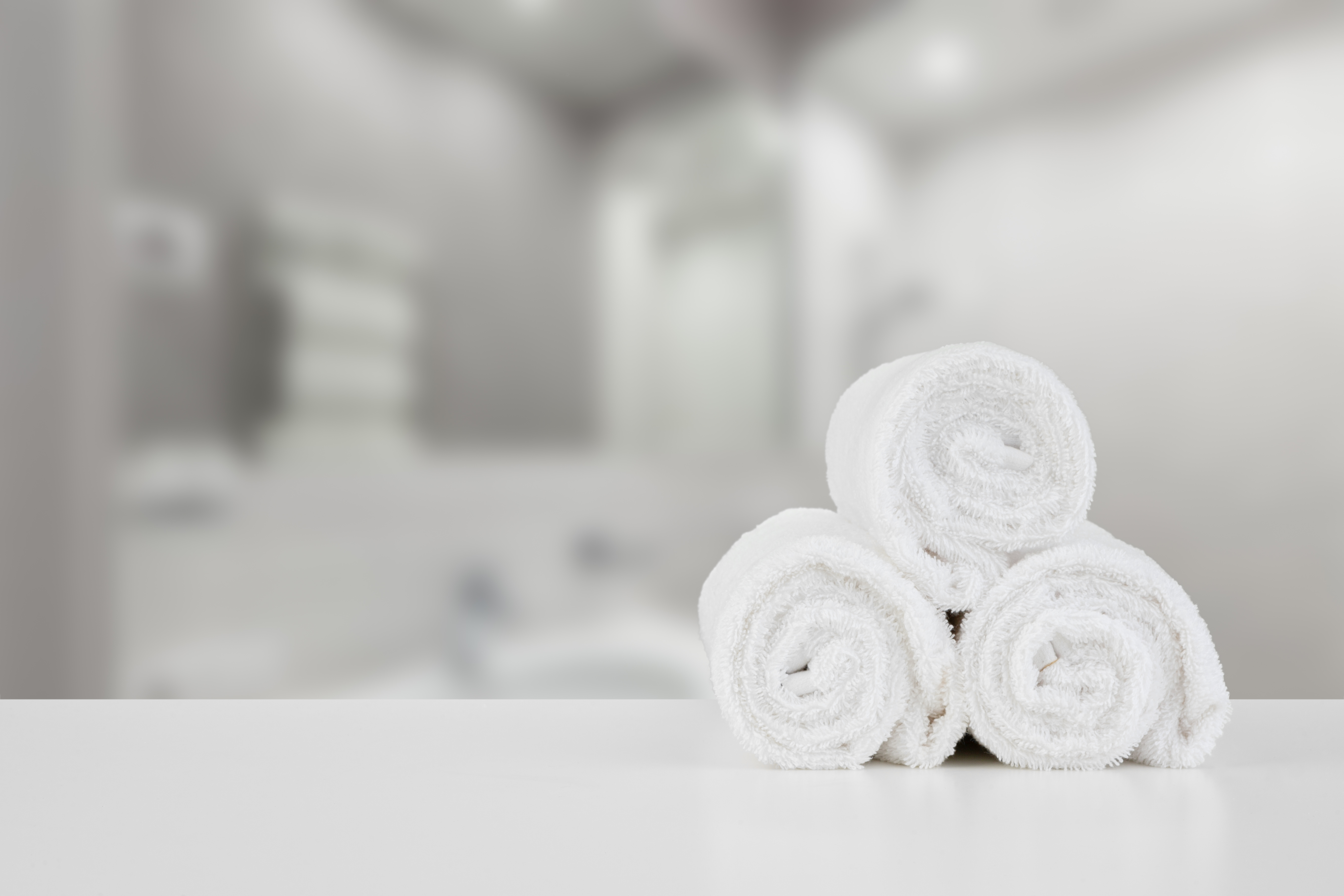 stacked-white-spa-towels-table-against-blurred-background.jpg