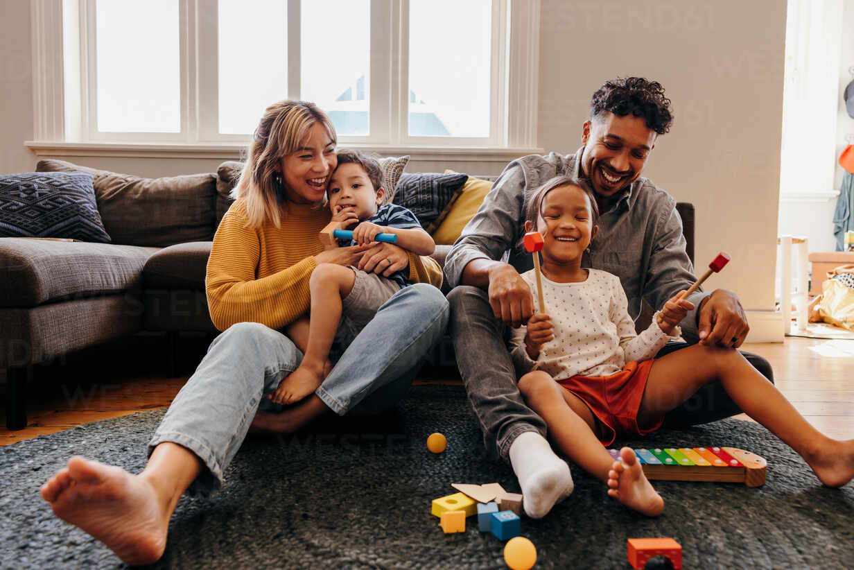 loving-parents-playing-with-their-son-and-daughter-in-the-living-room-mom-and-dad-having-fun-with-their-kids-during-playtime-family-of-four-spending-some-quality-time-together-at-home-jlpsf11338.jpg