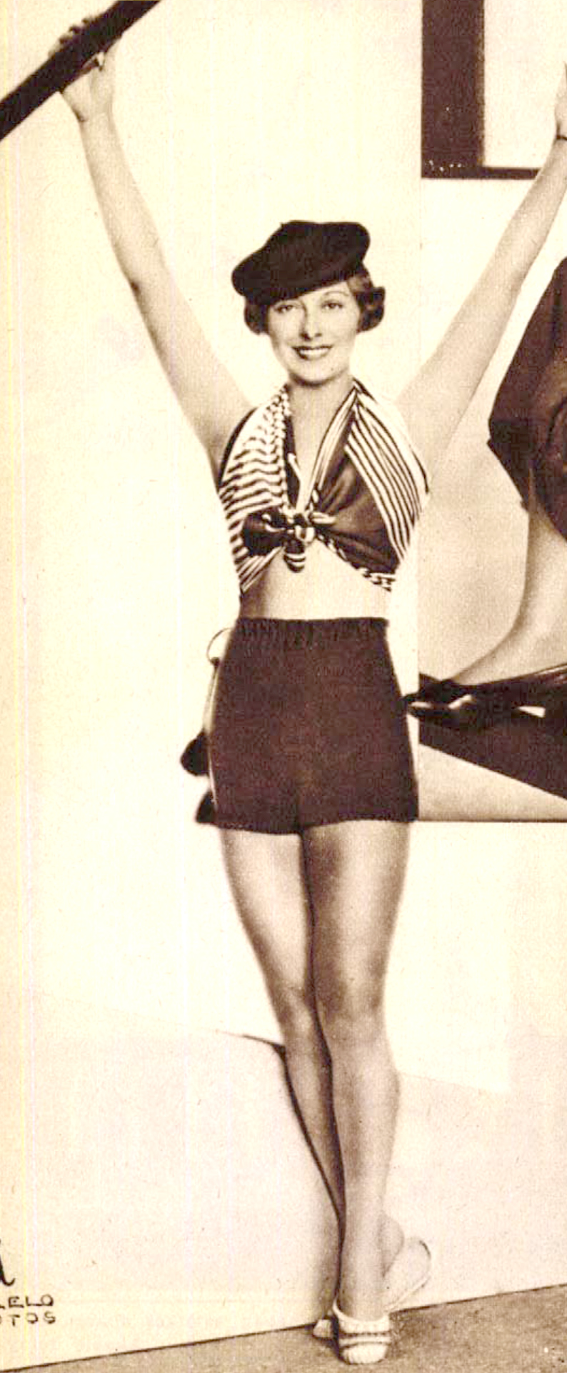 Muráti Lili divatos strandruhájában: barna trikó-short, barna-fehér karton kendő derékkal. (Színházi Élet 1934/29.sz. 37.)