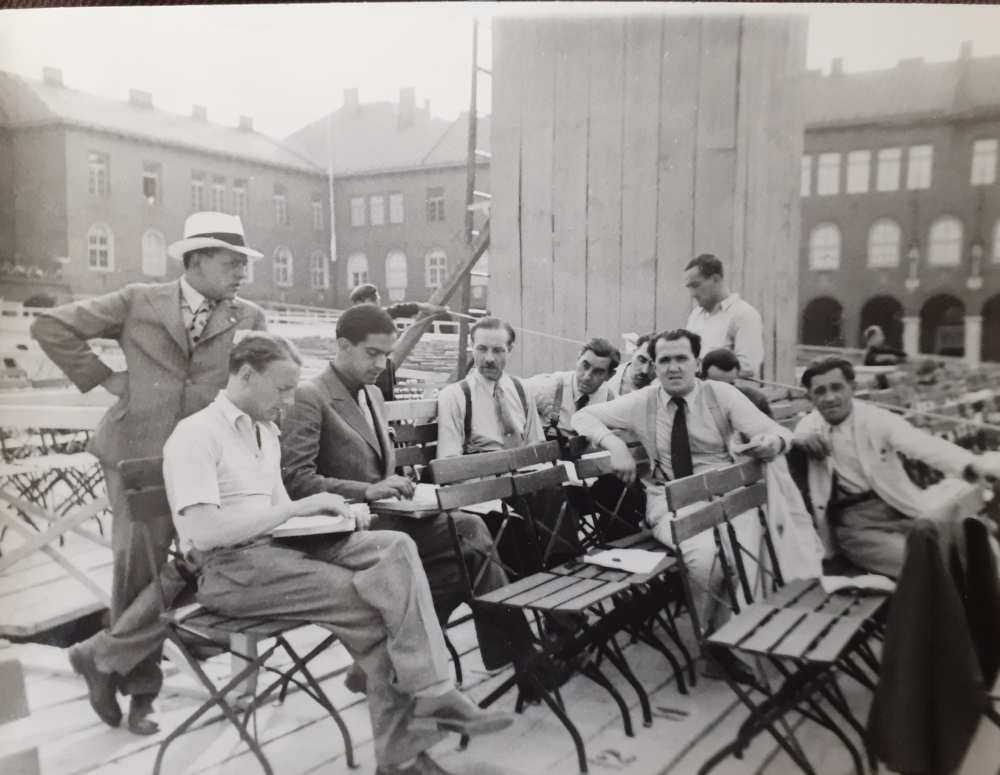 Madách Imre: Az ember tragédiája. Szeged, Dóm tér, 1934. augusztus 1. A képen jól látszik a vetítőtorony alsó része. Balról jobbra a harmadik maga a rendező, Oláh Gusztáv. Jelzet: KA 7848/11 – Színháztörténeti és Zeneműtár színháztörténeti gyűjtemény