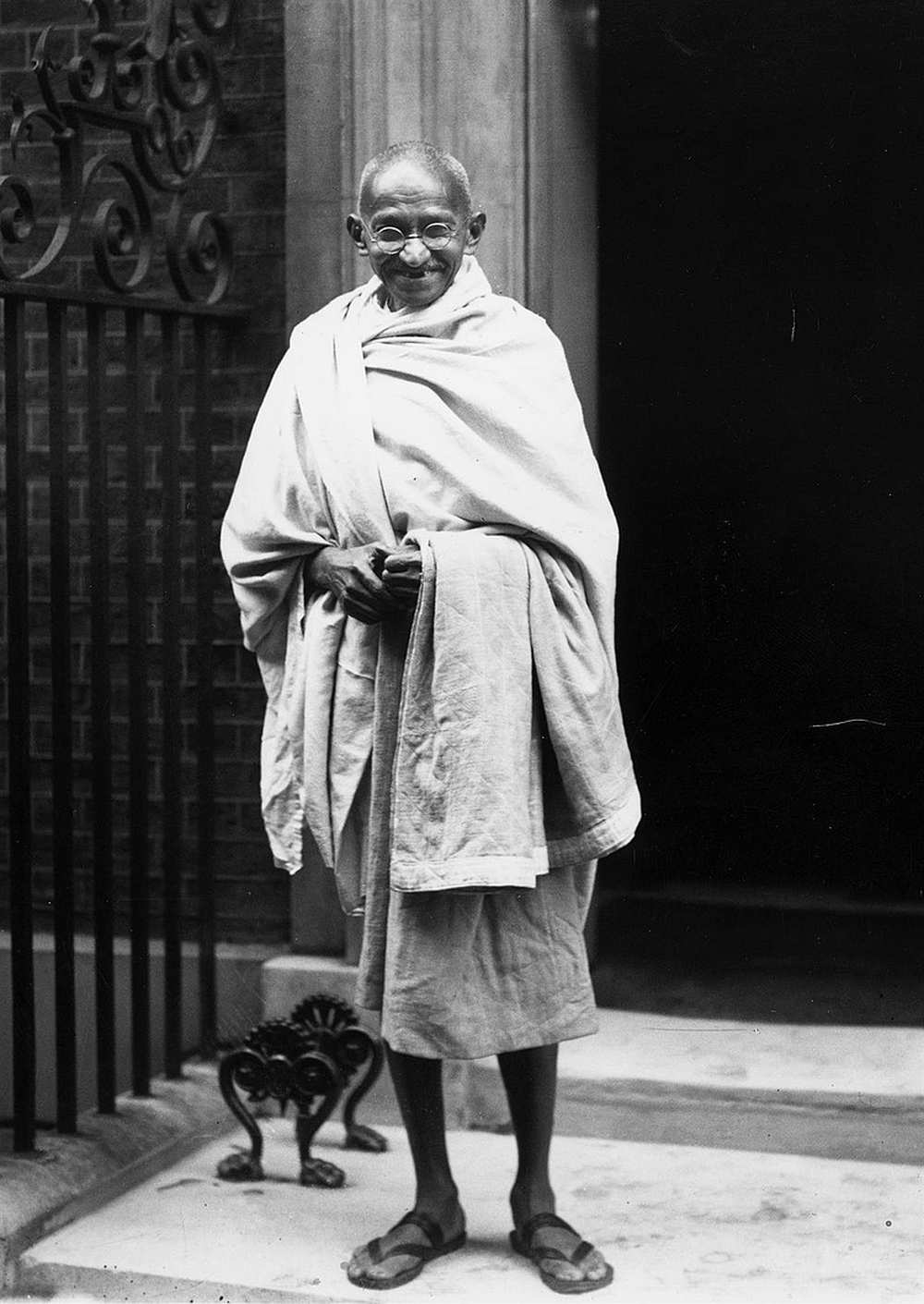 Gándhi a  Downing Street 10. előtt 1931. november 3-án. A kép forrása: Mohandas K. Gandhi. In: Mohandas K. Gandhi. In: Wikipédia (angol nyelvű kiadás) https://commons.wikimedia.org/wiki/Mohandas_K._Gandhi#/media/File:Gandhi_outside_10_Downing_Street,_London.jpg