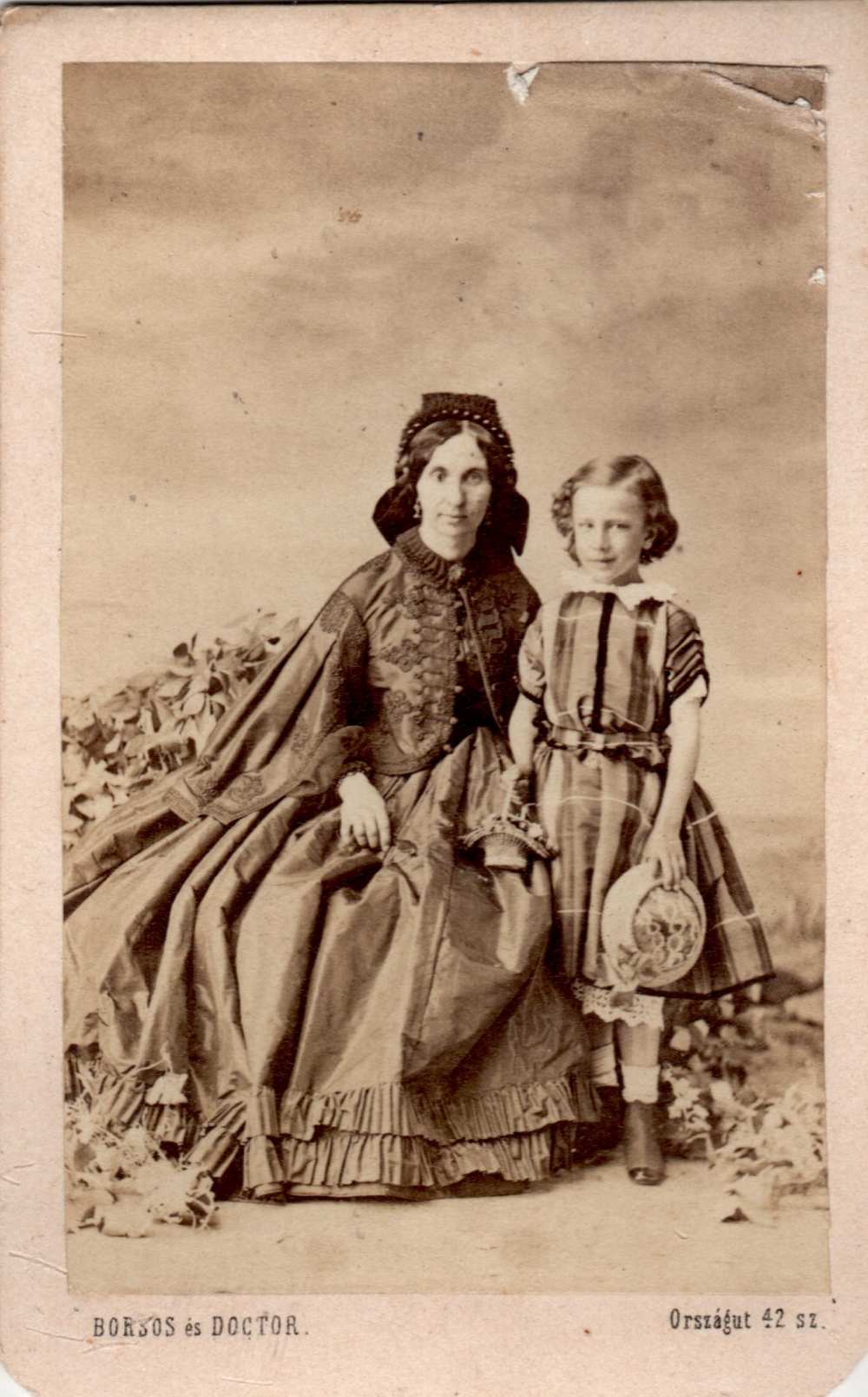 Borsos és Doctor: Magyaros ruhát viselő női és egy kislány műtermi portréja, növényekkel – Magángyűjtemény