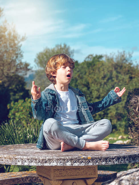 focused_232390624-stock-photo-adorable-little-boy-sitting-meditating.jpg