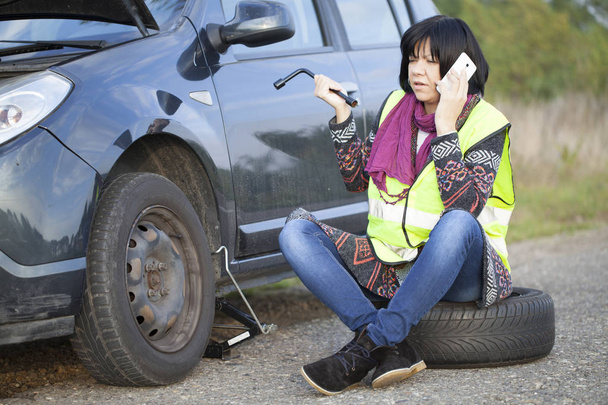 stock-photo-woman-changing-wheel-car-empty-road-selective-focus-small-depth.jpg