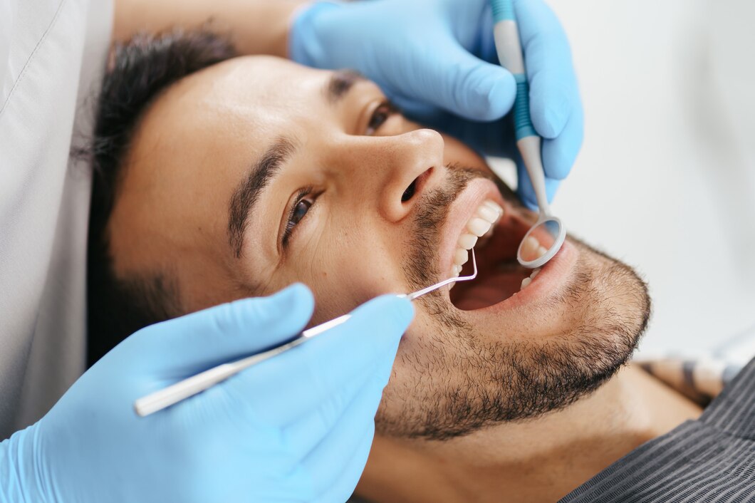 smiling-young-man-sitting-dentist-chair-while-doctor-examining-his-teeth_158595-7733.jpg
