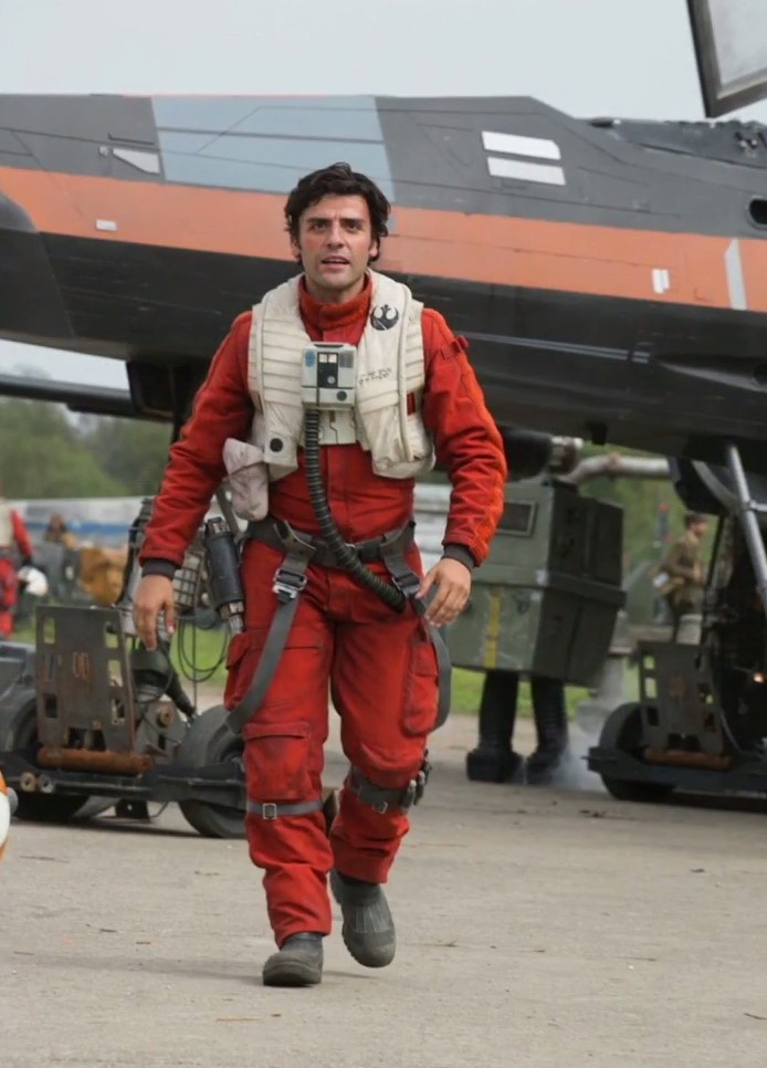 Oscar Isaac a pilóta öltözetben. A háttérben egy klasszikus ‘energia droid‘.