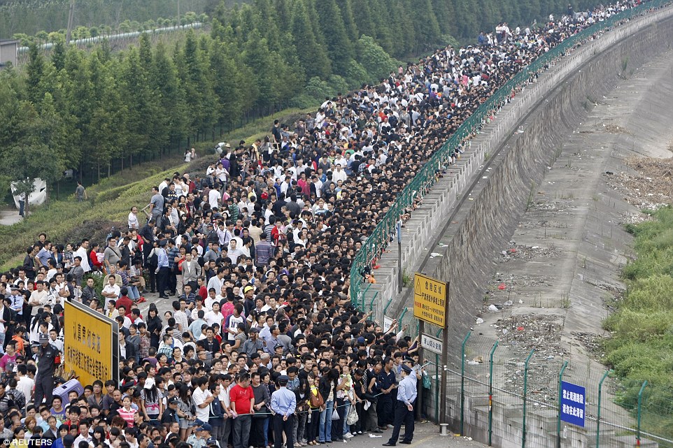 Ezrek várják a torlóárat a Qiantang folyónál Hangzhouban, Zhejiang tartományban 2010-ben