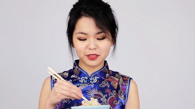 stock-footage-pretty-young-chinese-woman-eating-noodles-from-a-bowl-with-chopsticks.jpg