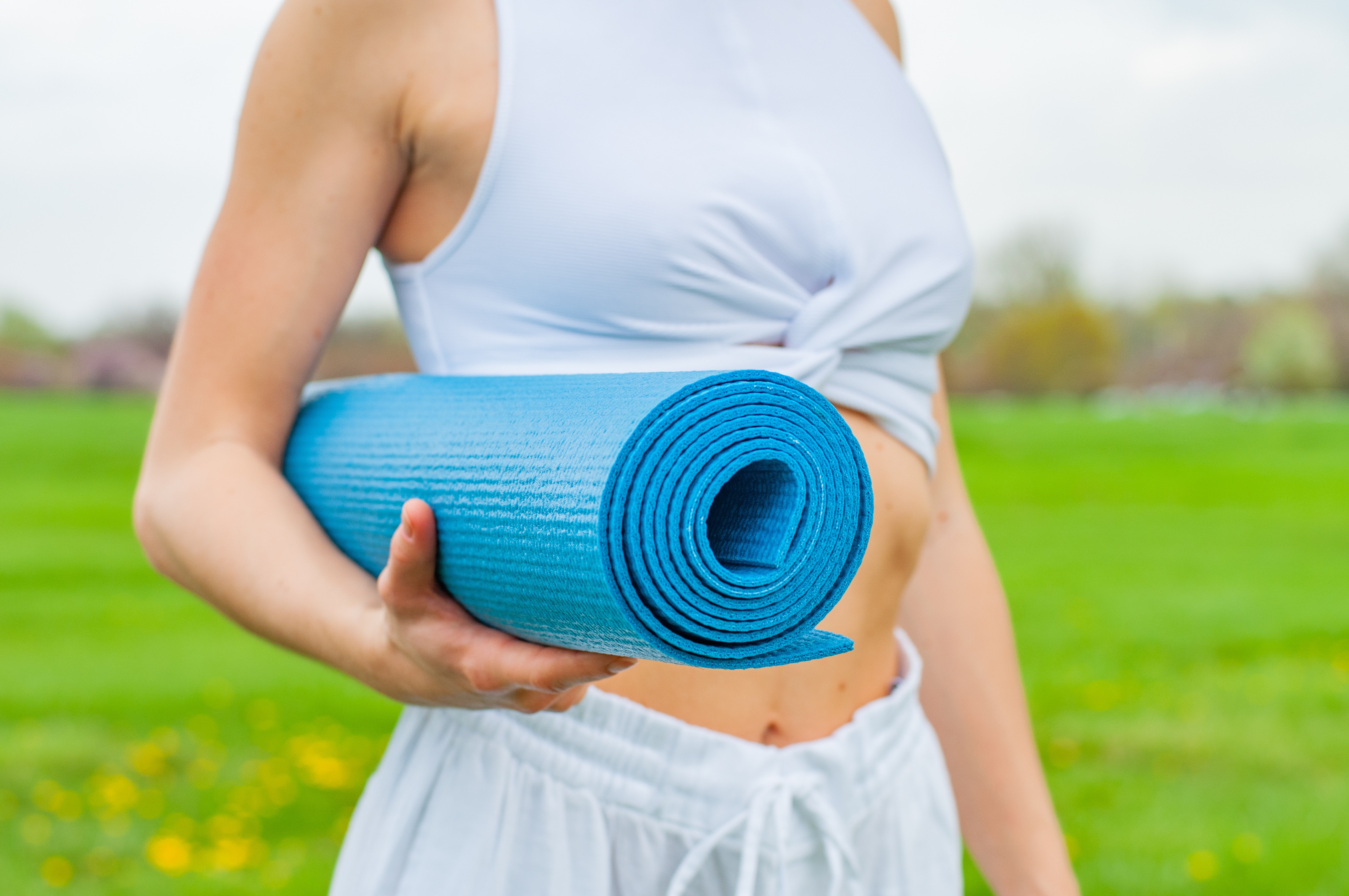 woman-standing-and-holding-blue-yoga-mat-2394051.jpg