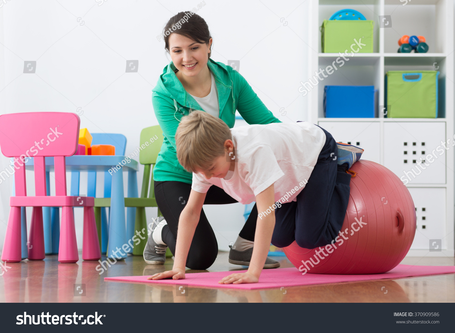 stock-photo-boy-exercising-with-instructor-on-gym-ball-370909586.jpg