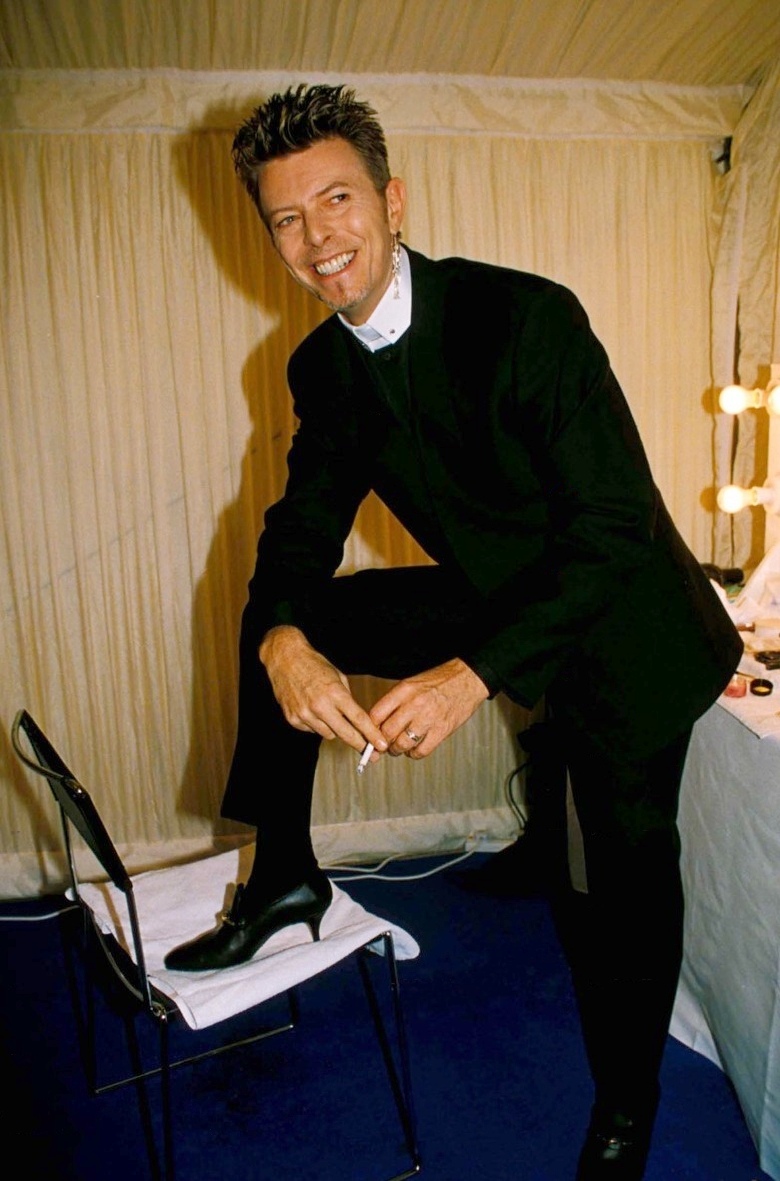1996: És ha a pap szerkó nem lett volna elég, vigyorogva mutatja a női cipőt a lábán.