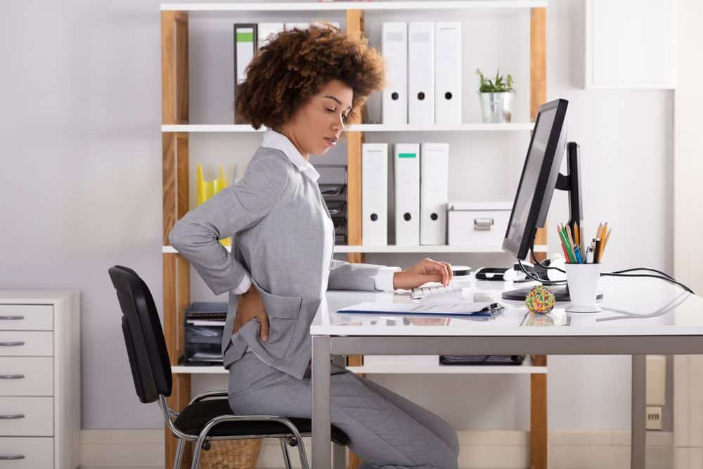 home-office-setup-ideas-adjustable-height-workstation-woman-at-a-desk-with-a-sore-back.jpg
