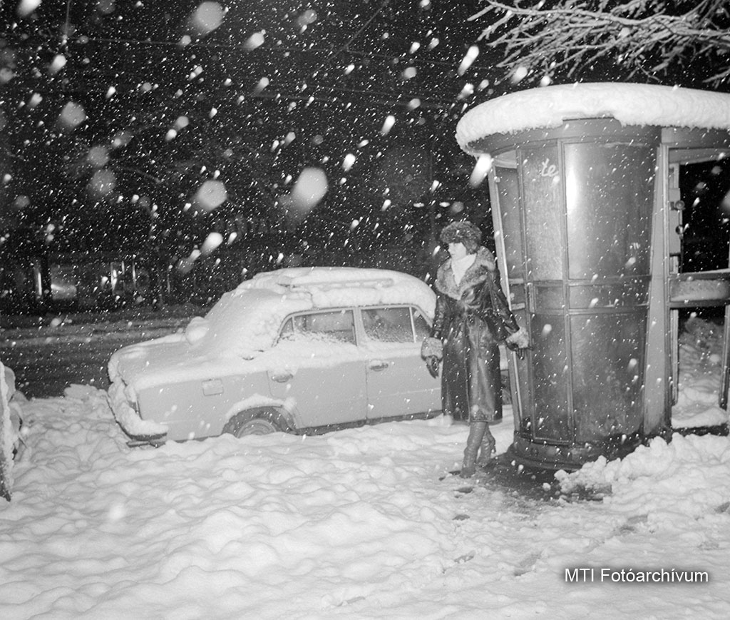 1980. december 1. Budapest. Jellegzetes, gombatetejű műanyag telefonfülkéből lép ki egy járókelő a sűrű havazásban. Mellette egy Lada személygépkocsi. MTI Fotó: Kerekes Tamás