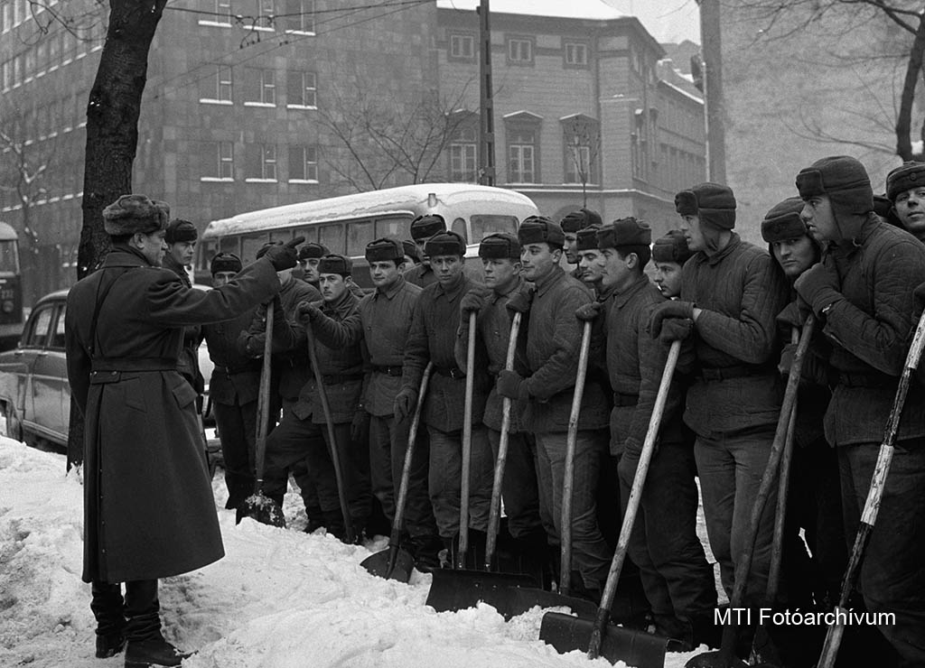 1963. február 4. A napos tiszt a Petőfi laktanya katonái számára kiadja a hóeltakarítással kapcsolatos utasítást. Több száz önkéntes segít Budapesten a hóeltakarításban, a Magyar Néphadsereg katonái önként jelentkeztek a munkára. MTI Fotó: Molnár Edit