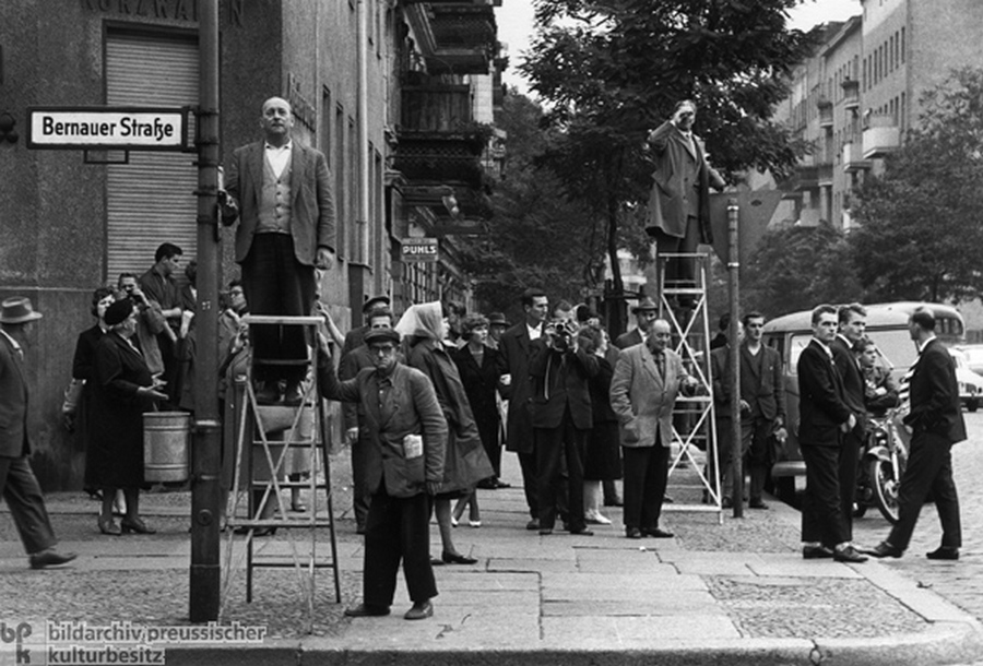 1961. Augusztus 13. Bernauer Strasse. Nyugat-Berliniek figyelik az épülő falat..jpg