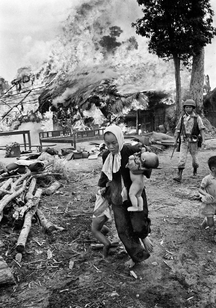 1963. Civilek menekülnek égő falujukból, mögöttük dél-vietnami katona..jpg