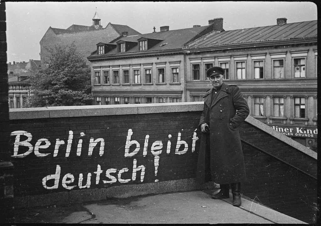 1945_majus_berlin_nemet_marad_hirdeti_a_graffiti_ami_elott_egy_szovjet_tiszt_all_a_megszallt_egykori_naci_nemetorszag_fovarosaban.jpeg