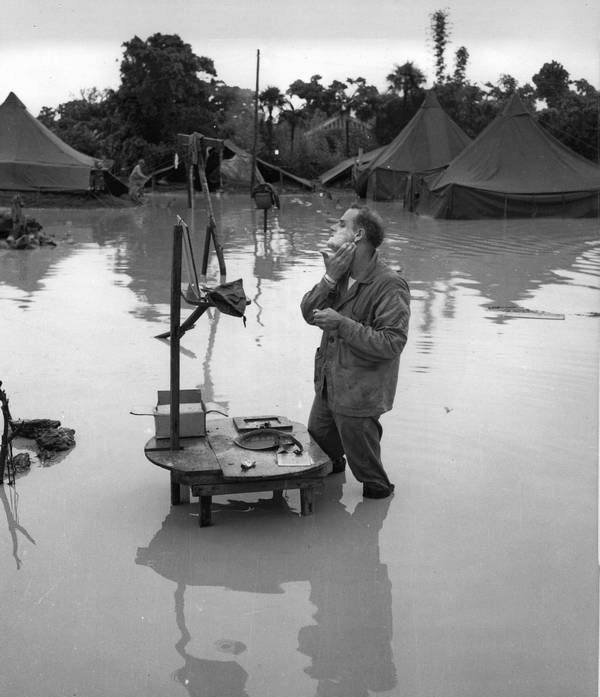 1945_majus_25_u_s_marine_corps_staff_sergeant_a_s_barnacle_shaves_in_the_flooded_campground_during_a_lull_in_the_battle_of_okinawa.jpg