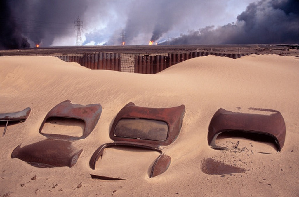 1991_kuwait_car_cemetery_in_the_background_burning_burgan_oil_fields_set_on_fire_by_retreating_iraqi_troops.jpg