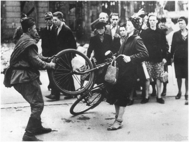 1945. Szovjet katona próbálja erőszakkal megvásárolni egy német nő biciklijét..jpg