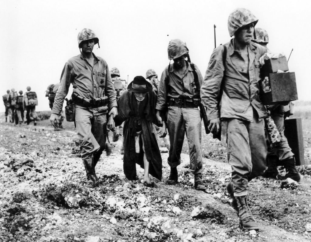 1945_junius_u_s_marines_help_escort_an_elderly_japanese_civilian_away_from_the_front_lines_during_the_battle_of_okinawa.jpg