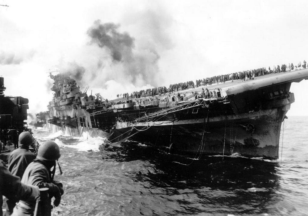 1945_marcius_19_the_uss_santa_fe_lies_alongside_the_heavily_listing_uss_franklin_to_provide_assistance_after_the_aircraft_carrier_had_been_hit_and_set_afire_by_a_single_japanese_dive_bomber.jpg