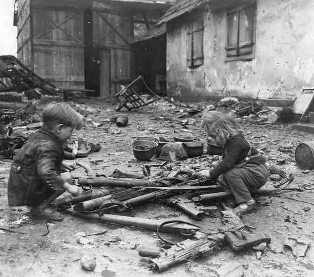1945_majus_children_play_amid_weapons_abandoned_in_ruins_of_nazi_germany.jpg