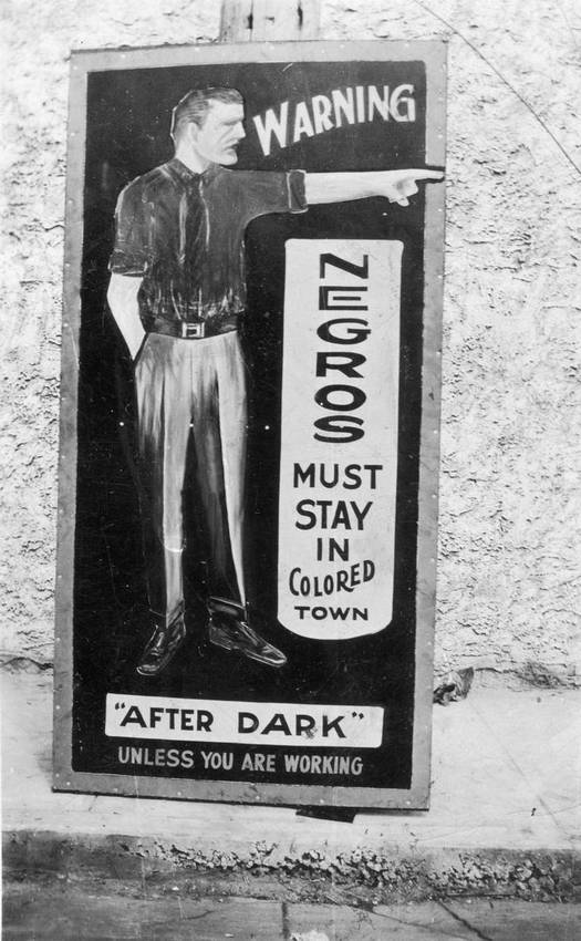 1940s-50s_negro_warning_sign_to_stay_away_from_white_area_crudely_painted_white_man_points_toward_colored_town_cr.jpg
