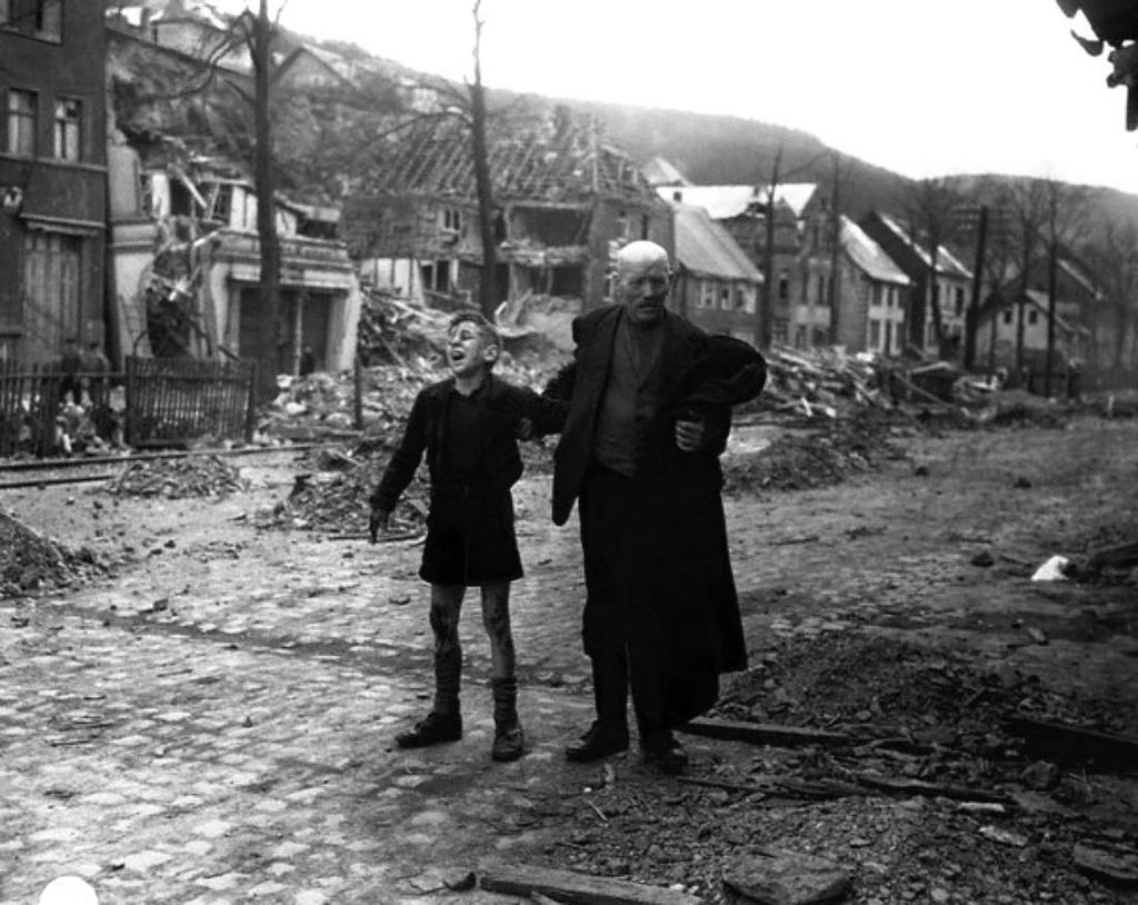 1945_german_man_rushes_a_young_boy_screaming_in_pain_to_an_allied_aid_station_after_the_boy_picked_up_a_pair_of_shoes_that_booby_trapped_with_explosives_by_retreating_ger_soldiers_altenbunnen.jpg