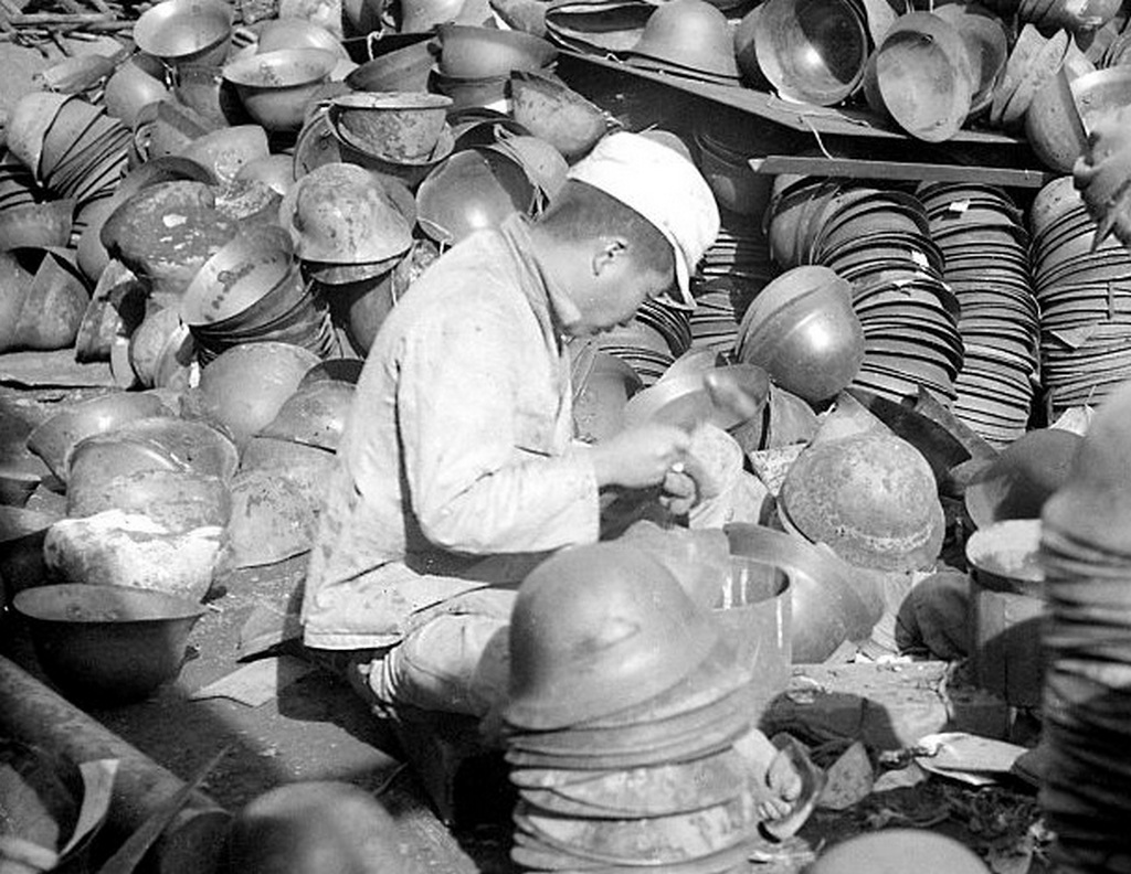 1945_meanwhile_at_roughly_the_same_time_on_the_other_side_of_the_world_a_young_japanese_hired_by_the_us_army_cleans_and_stacks_m30-32_tetsu-bo_helmets.jpg