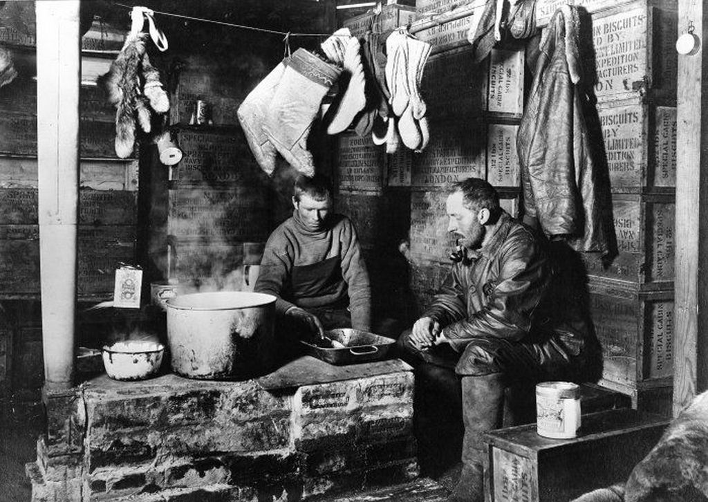 1911_cecil_meares_and_dimitri_girev_at_the_blubber_stove_in_the_scott_s_discovery_hut_at_hut_point_november_3_1911.jpeg