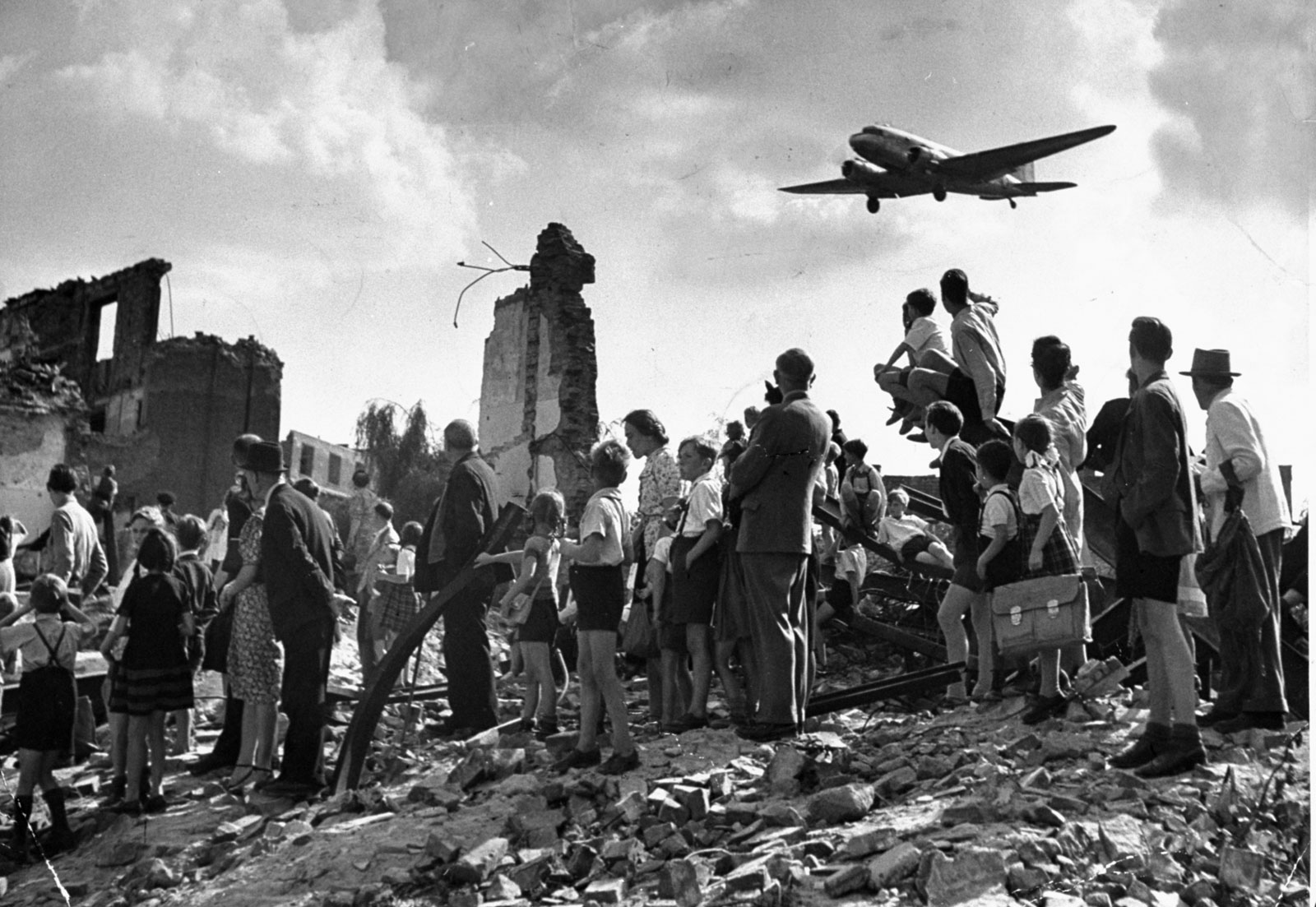 1948. Nyugat-Berliniek nézik a légihídon át ellátmányt szállító C47-es repülőt, ami leszállni készül a Tempelhof reptéren..jpg
