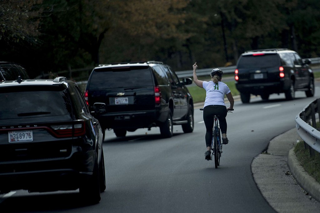 2017_10_28_juli_briskman_riding_her_bike_gestures_with_her_middle_finger_as_a_motorcade_carrying_president_donald_trump_departs_trump_national_golf_course_in_sterling_virginia.jpg