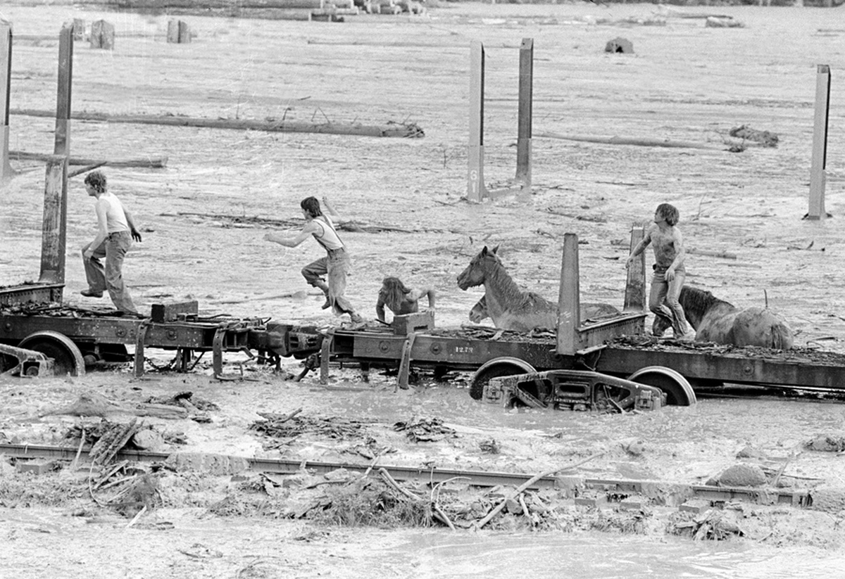 1980_may19bob_and_john_brown_climb_onto_railroad_car_heading_down_the_train_along_with_two_horse_rescuers_giving_up_their_efforts_as_they_flee_for_their_lives_as_flood_waters_from_the_toutle_river_begin_a_sudden_rise.jpg