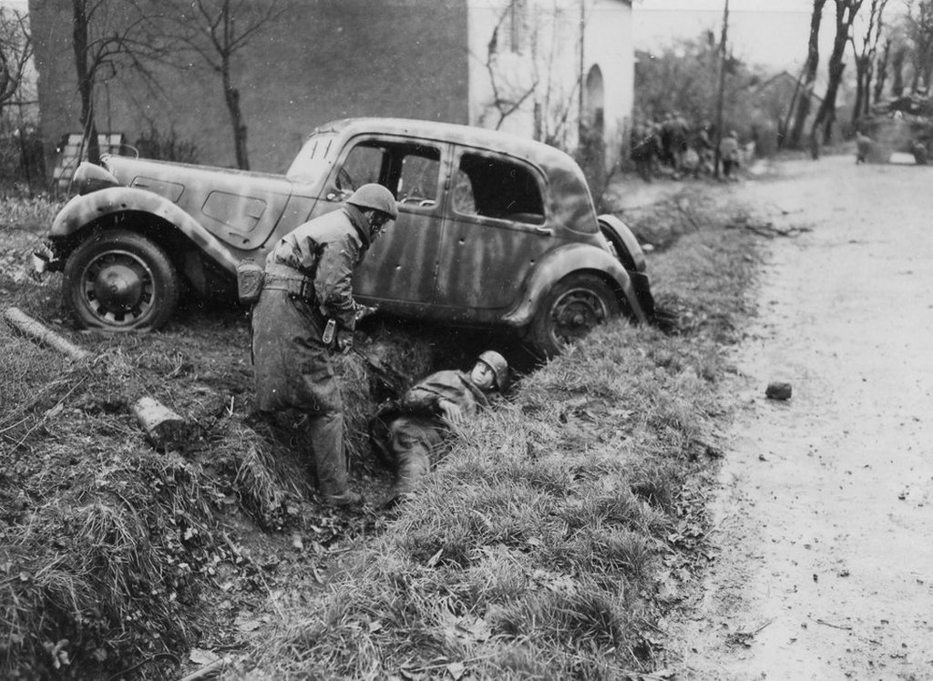 1944_november_20_a_soldier_of_the_2nd_battalion_de_choc_french_commandos_takes_a_german_prisoner_behind_a_shattered_staff_car_during_a_firefight_in_belfort_france.jpg