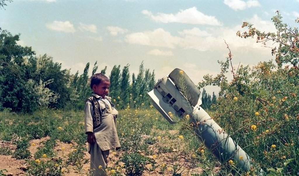 1989_a_young_afghan_boy_observing_an_unexploded_bomb_dropped_by_russian_forces_in_the_soviet_afghan_war.jpg