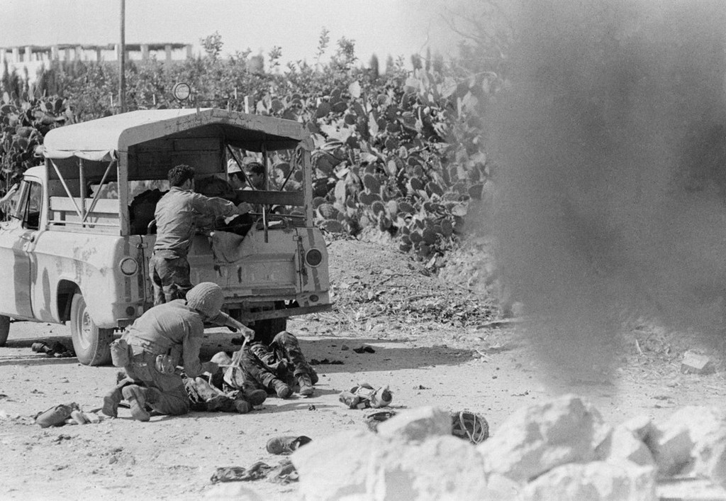 1967_junius_6_israeli_soldier_gives_first_aid_treatment_to_men_injured_when_a_car_full_of_newsmen_was_blown_up_by_a_booby-trapped_stone_barricade_left_by_retreating_egyptians_on_the_road_to_gaza.jpeg