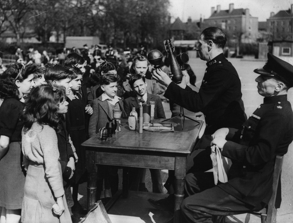 1943_children_in_hackney_uk_are_advised_on_road_safety_and_the_dangers_of_picking_up_strange_objects_by_police_officers.jpeg