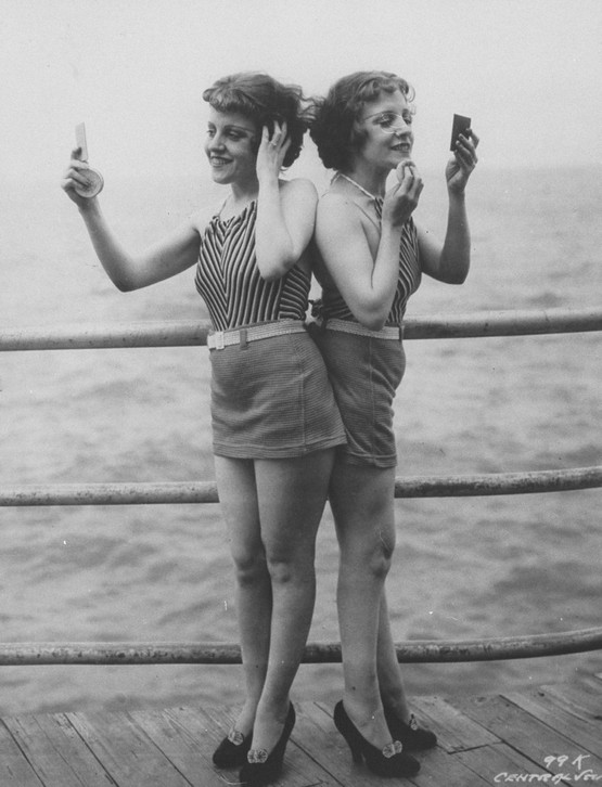 1946_siamese_twins_violet_daisy_hilton_standing_back-to-back_looking_in_hand_mirrors_and_powdering_faces_on_pier_at_atlantic_city.jpeg