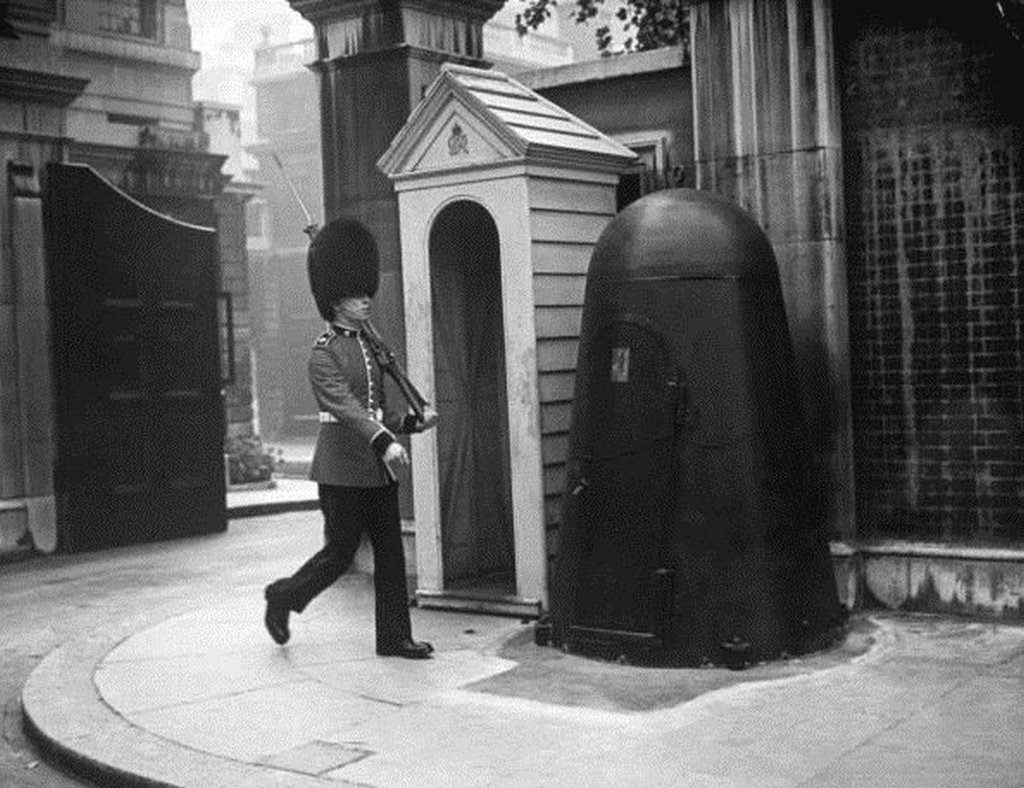 1940_a_queen_s_guard_with_an_individual_air_raid_shelter_next_to_sentry_box_during_the_blitz_london.jpg