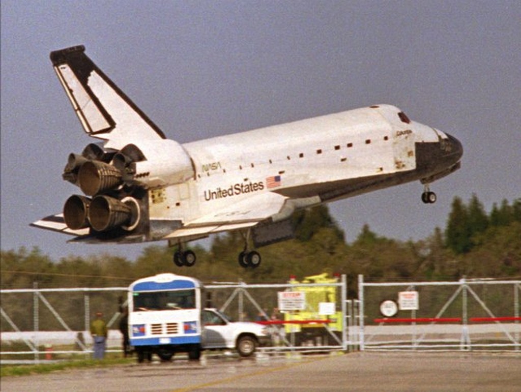 1996_the_space_shuttle_columbia_glides_by_rescue_vehicles_before_touching_down_on_kennedy_space_center_s_runway_33_early_saturday_morning_march_9_1996_ending_a_16-day_mission.jpg