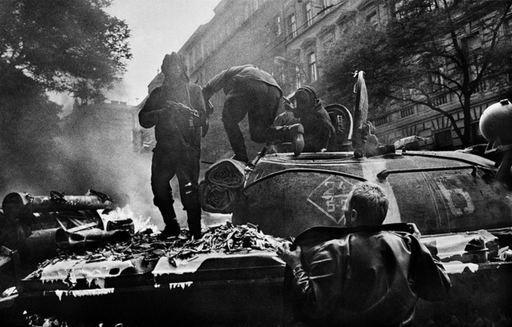 1968_a_russian_tanker_aims_his_akms_rifle_at_a_czech_protester_while_the_rest_of_his_crew_exit_their_t-62_after_molotovs_ignited_the_engine_afire_prague.png