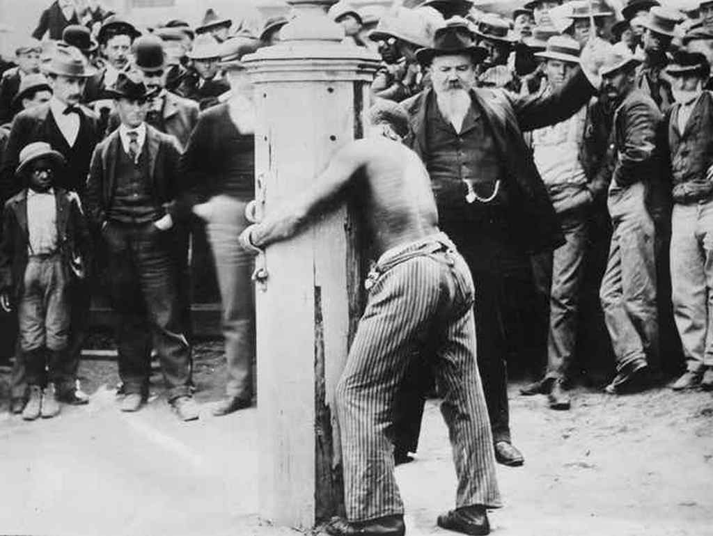 1900_a_black_man_is_punished_for_a_crime_by_being_tied_to_a_whipping_post_and_publicly_flogged_in_delaware_us.jpg