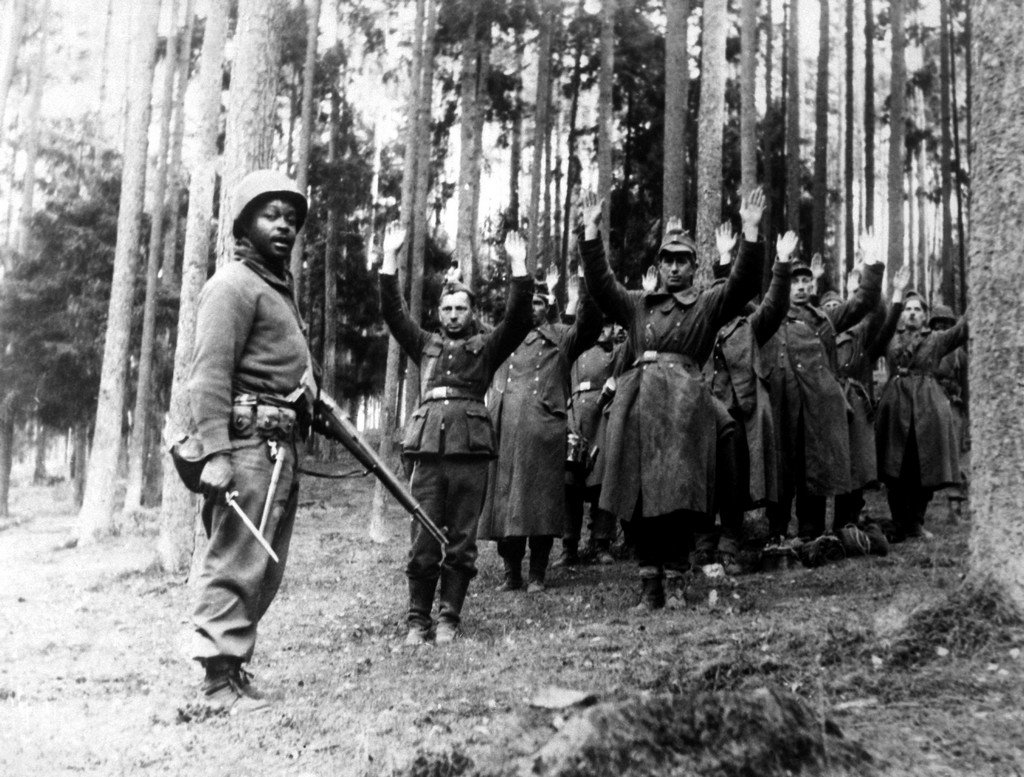 1945. Afroamerikai katona felügyel a magukat megadó német katonákra..jpg