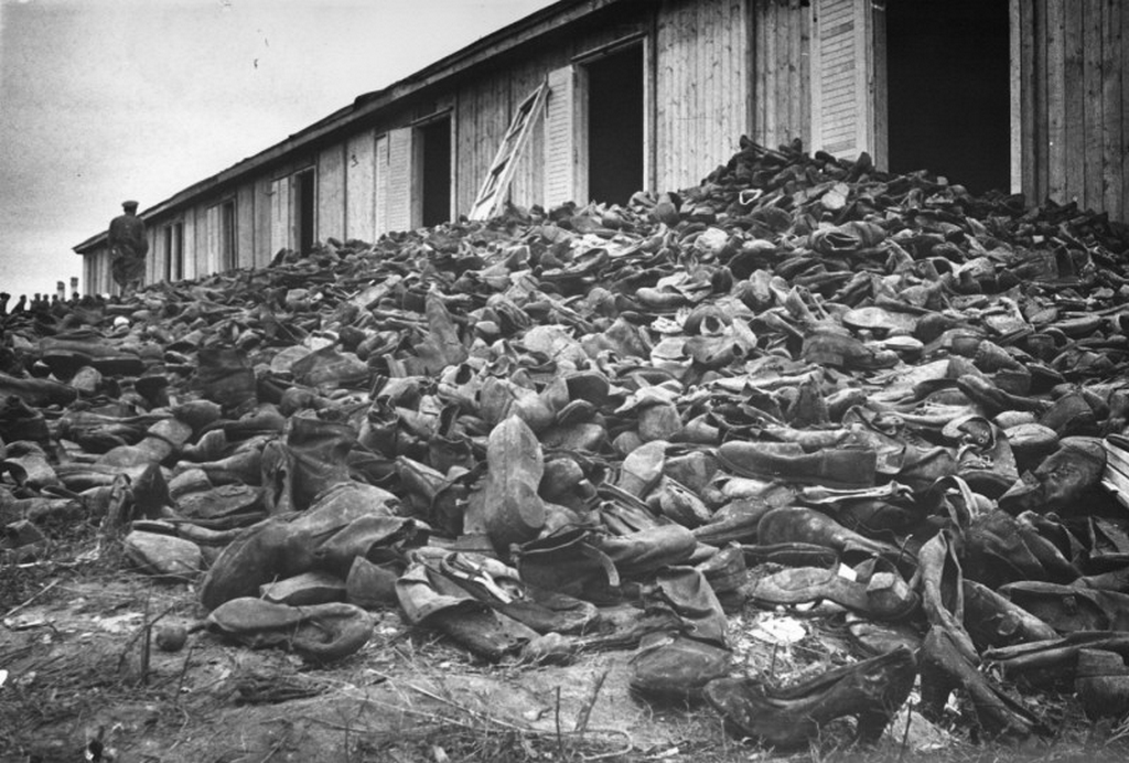 1944_a_soviet_soldier_walks_through_a_mound_of_victims_shoes_shortly_after_the_liberation_of_majdanek_concentration_camp_poland.png