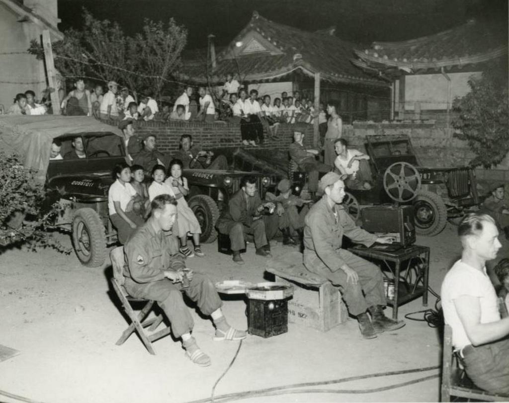 1952_us_army_personnel_and_korean_villagers_gathering_to_watch_an_outdoor_movie_screening_south_korea.jpg