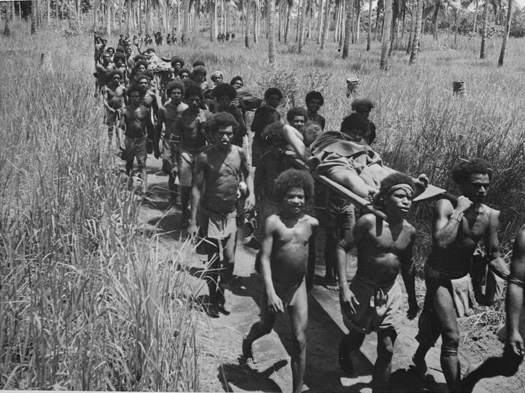 1942_native_villagers_carrying_wounded_allied_soldiers_to_an_american_aid_post_near_buna_new_guinea.jpg