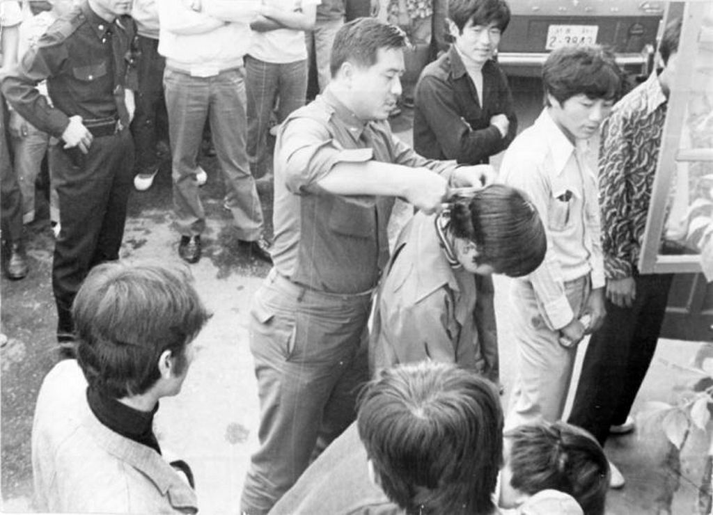 1975_a_south_korean_soldier_forcibly_cuts_a_young_man_s_hair_in_front_of_others_during_a_nationwide_crackdown_on_men_with_long_hair.jpg